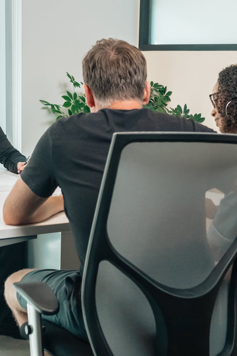 A business advisor consults with clients in a modern office setting, fostering teamwork and cooperation.